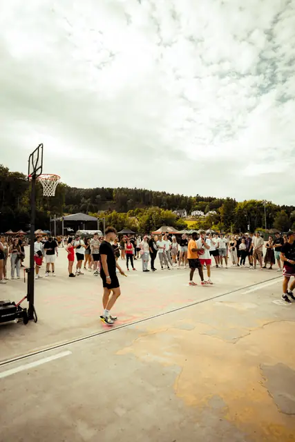 Basketbalové hřiště a návštěvníci v areálu festivalu odpoledne, Liberec 2023